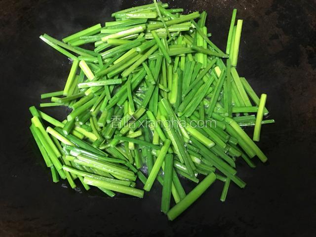 锅内留余油，韭苔入锅翻炒；