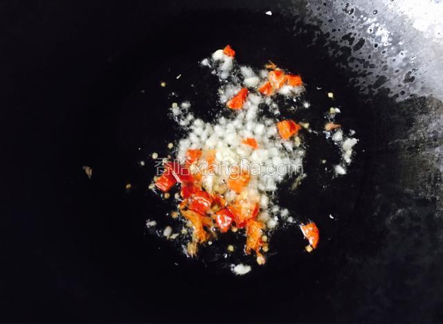 热锅放油烧至六成热，放入大蒜，干辣椒爆香。