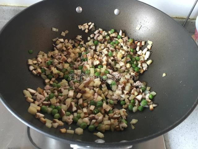 炒锅入油，依次下入肉丁、豆干、香菇、青豆、榨菜丁、笋丁等食材；