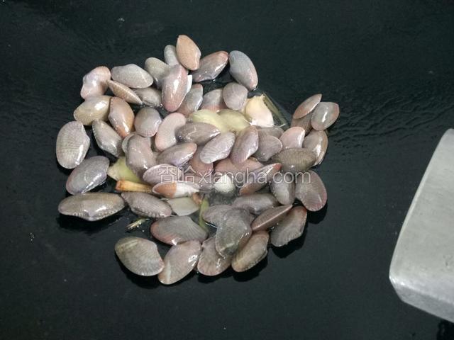 用铲子把花蛤铺平，均匀受热