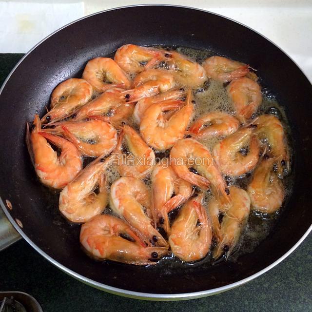 锅内多倒油，烧至约六七成热，把虾倒入，迅速翻面，待虾变红起酥即可捞出。