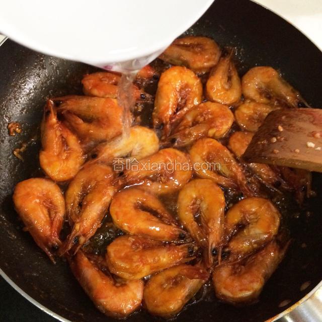 用铲子轻压几下虾脑，挤出红汁，大火翻炒，加入小半碗温水，大火烧开，小火焖盖。