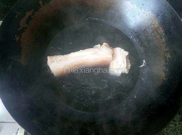将五花肉在滚水里飞水，煮一下。