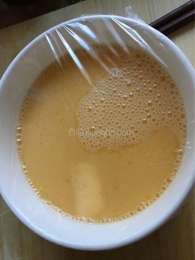 盖上保鲜膜，电饭锅加一碗清水，按煮饭键，鸡蛋液之间凉水入锅，盖好盖。