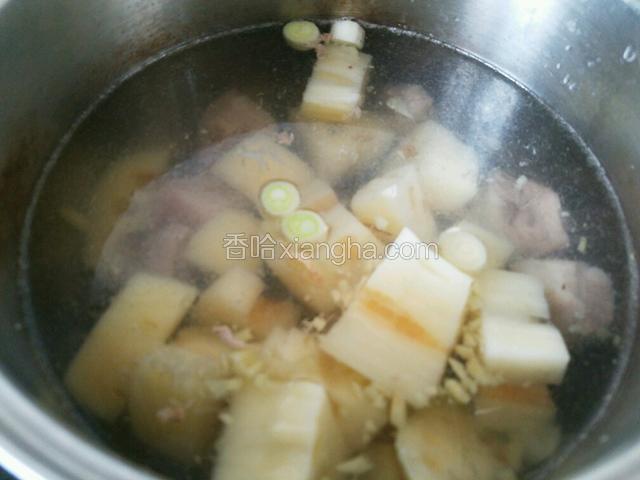 从容器里捞出莲藕放入汤锅中，盖上锅盖，锅滚起来后转小火慢炖一小时。