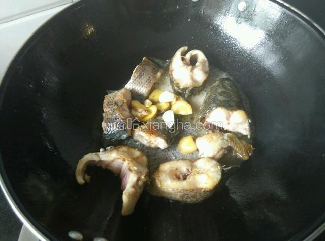 煎至两面金黄，下姜蒜，一勺料酒。