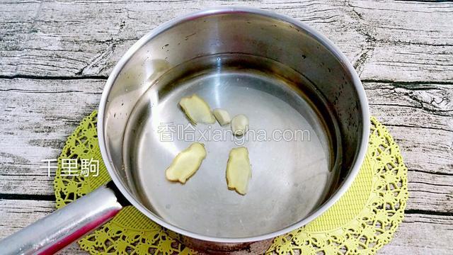 锅里下适量水、姜片和蒜瓣