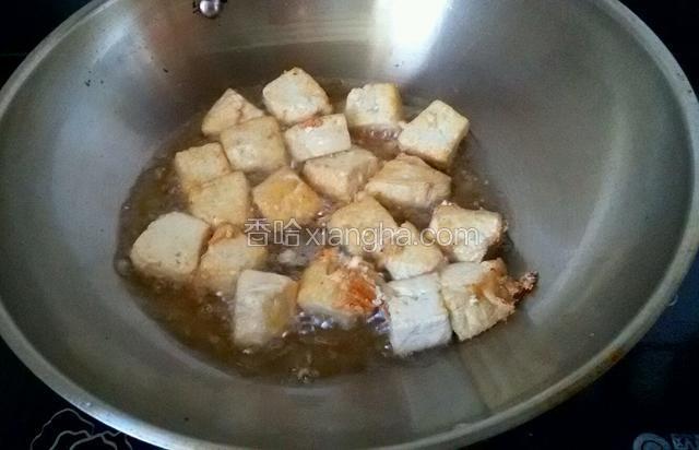 在锅中把豆腐炸一下。
