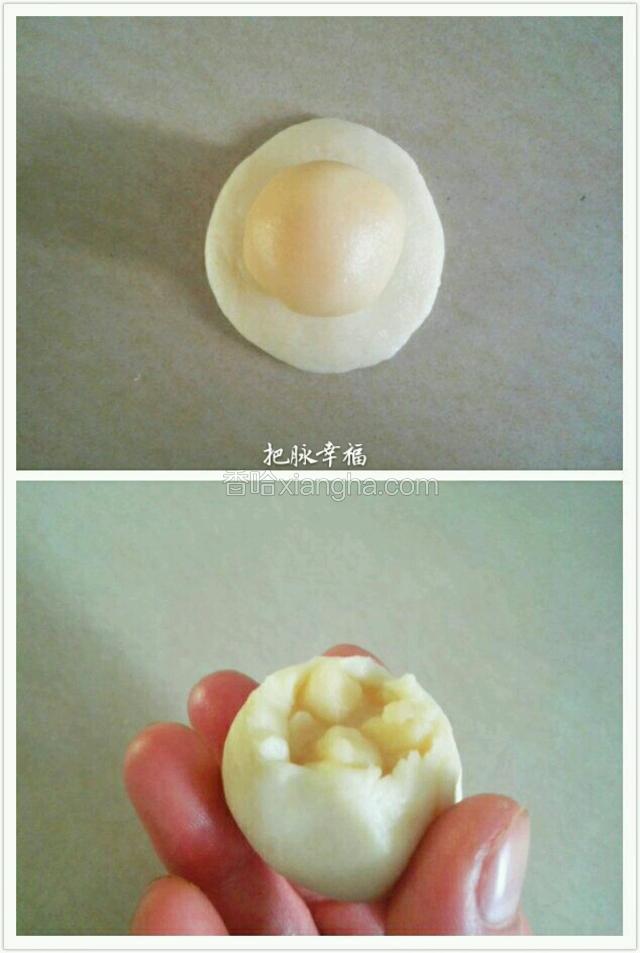 取一块水油皮按扁，放上油酥面。虎口慢慢往上推，把馅往里按进去，边转着按压边封口