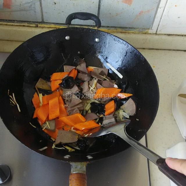 下入切好的羊肝，胡萝卜，木耳，一起翻炒，可加少许清水，以免木耳炸锅溅油。