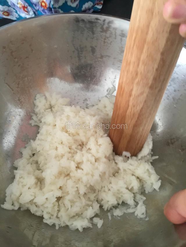 蒸熟后将其倒扣在一盆中，用一木棍来回舂