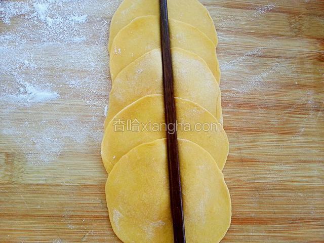 擀成饺子皮样，叠在一起，用筷子在中间压一下