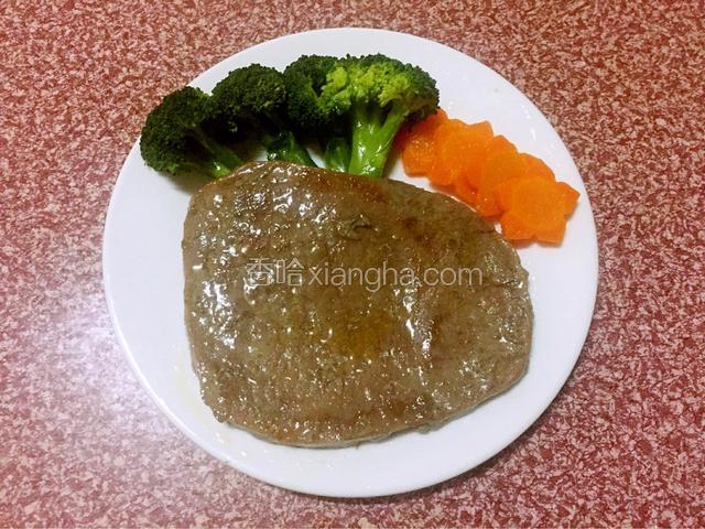 把胡萝卜、西兰花摆在盘中，然后用牛排夹从平底锅夹出牛排放到盘中