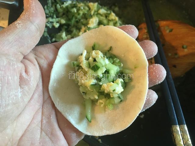 取一个饺子皮，放入适量的馅儿。