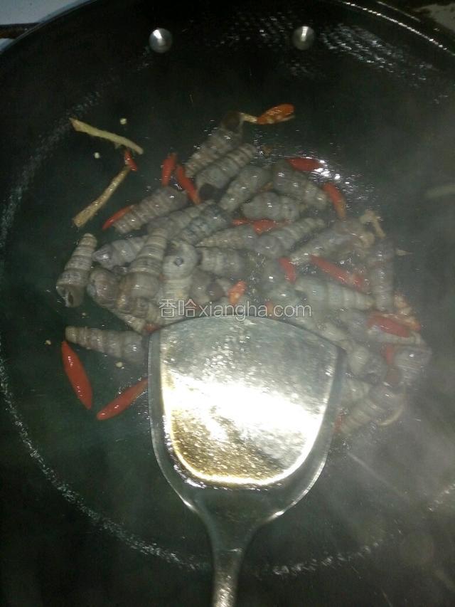 把钉螺倒进锅，放入朝天椒，加入老酒