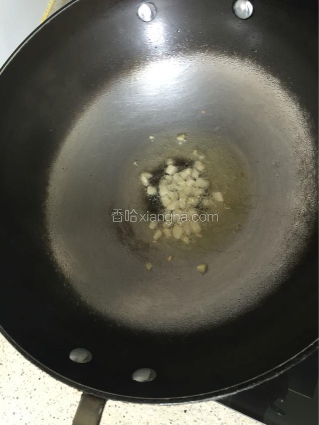 锅里倒入适量的油，放入蒜粒爆香。