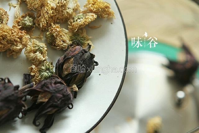 洗净的洛神花与菊花一同放入茶壶中；