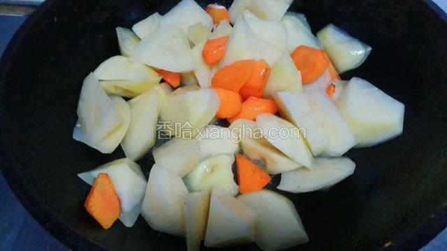 然后下土豆翻炒至七八成熟
