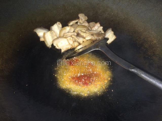 然后把肉拨到一边，关小火，放入豆瓣酱炒出红油，
