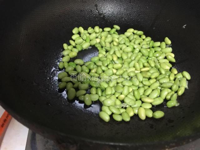 油热锅加入毛豆翻炒.变色之后加盐