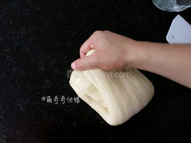 顺势用捏住面团的手弯曲过去将摔在案板上的面团收回来，如此重复摔打几次，此时的面团已经越来越软了。