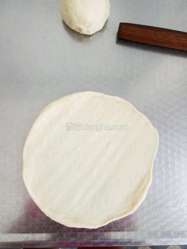 然后准备油纸或保鲜膜，最好是按自己的模具剪个圆行！我的是八寸戚风模具。擀好一个圆面片，放到保鲜膜上，拿出剩余的黄油，面片上抹上黄油防粘，再接着擀第二片！