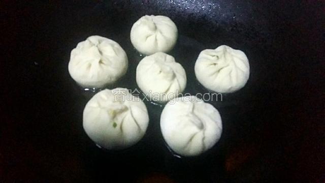 锅里放入适量的油，把饧好的包子放到锅里煎出金黄色。
