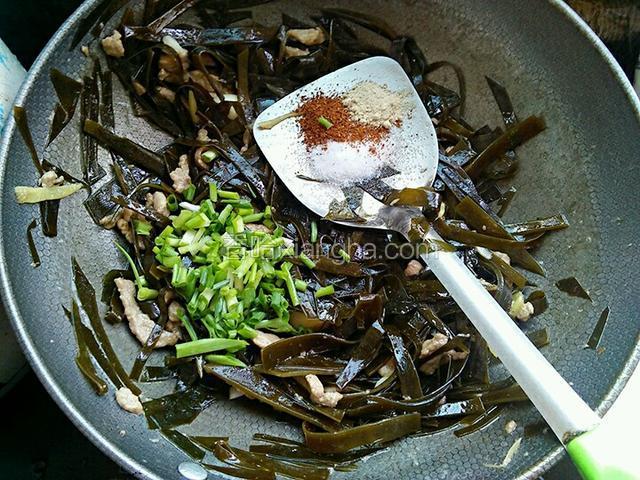 海带丝快炒熟的时候加入葱花，盐，花椒粉和鸡肉粉继续翻炒至熟