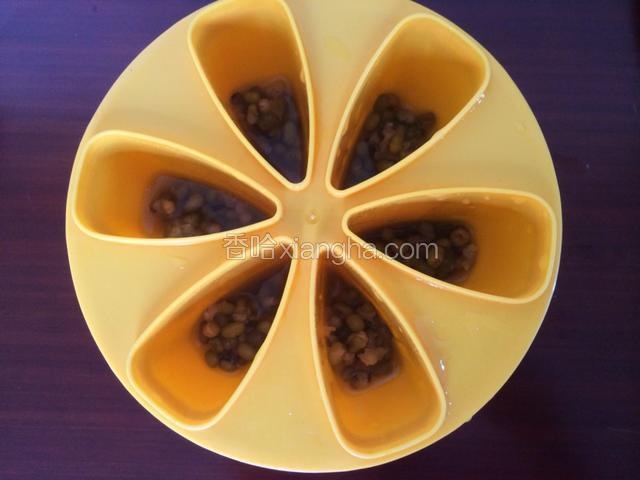 用勺子舀入绿豆，均匀的分布冰棒模具中（也可随意放）