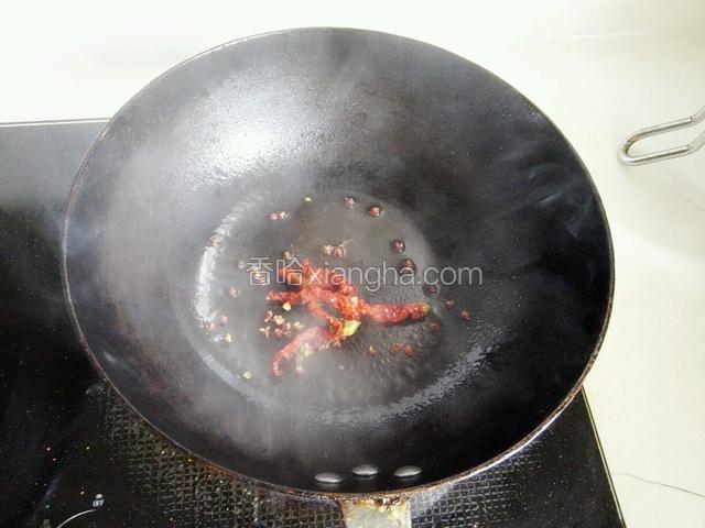 锅中倒入少量油爆香花椒粒和干辣椒