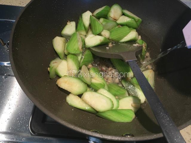 倒入适量清水，继续翻炒丝瓜，丝瓜变软后，放入3g盐，翻拌均匀，关火。