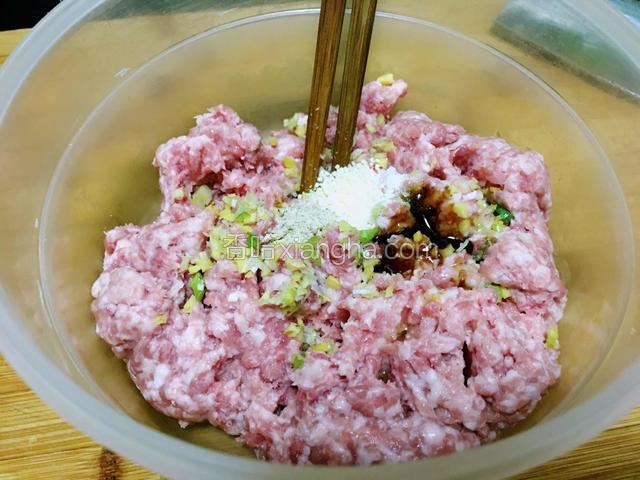 肉糜中放入葱姜末、胡椒粉、蚝油、盐、鸡精顺同一方向搅拌均匀