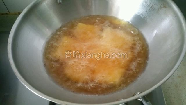 锅中加入适量油烧热下豆腐炸至金黄色