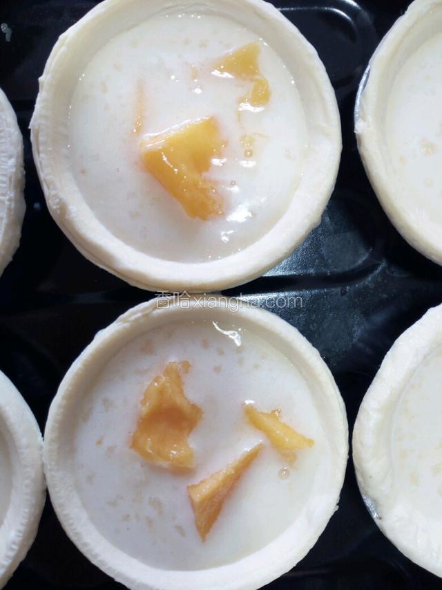 放入切好的芒果小块。也可先放芒果小块，然后再加蛋挞液。