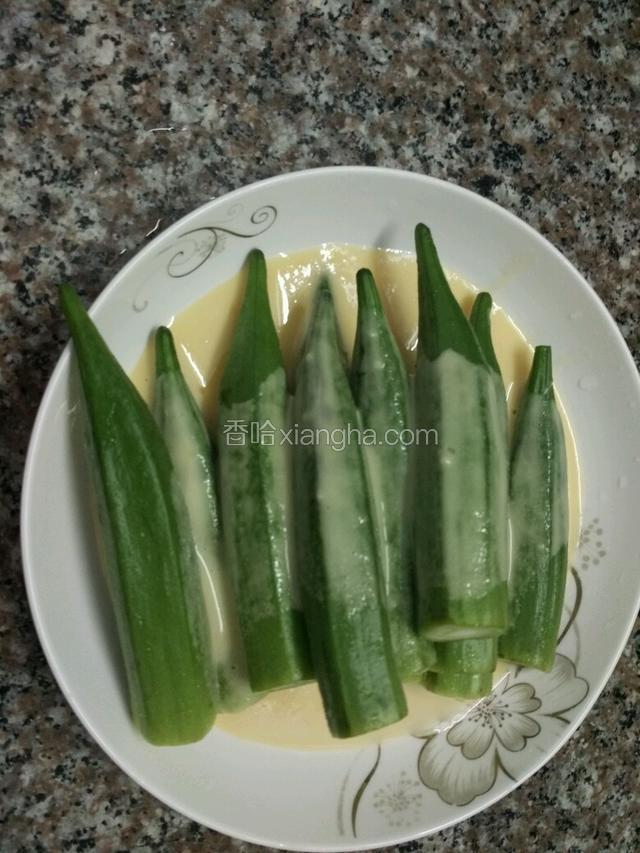 拌匀的糊淋在秋葵上面，每根都粘上糊糊；