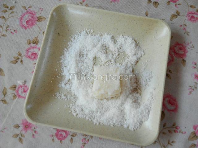 取一小碗倒入椰丝，把每一小块牛奶小方上滚满椰丝即可。