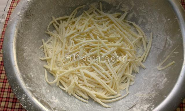 用擦丝器擦上一层土豆丝之后，端盆上下颠几下，使土豆丝都均匀的沾上面粉