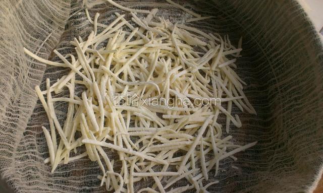 然后把沾了面粉的土豆丝放到蒸笼上，蒸笼里铺上湿的笼布