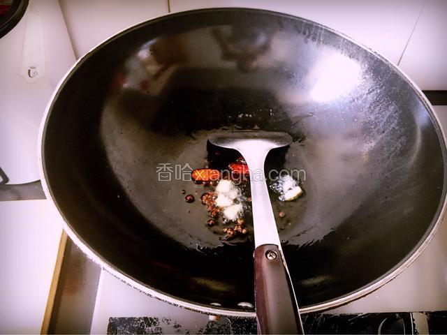 炒锅热油，放入生姜片及干红椒，爆出香味