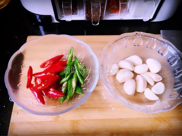 此时，将大蒜子去皮洗净，青红杭椒去蒂洗净，斜刀切成小段