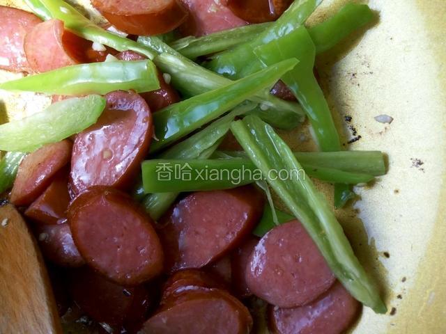把红肠拨到一边，放入蒜末煸香，再放入青椒丝，然后一起翻炒均匀，加入适量生抽，盐，鸡精调味即可