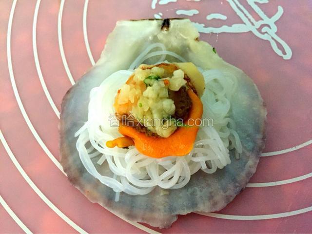 将处理干净的扇贝肉取下，放入粉丝，再将扇贝肉放回去，放上蒜末香菜末