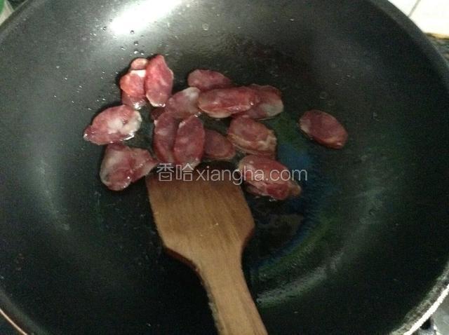 锅中注入少许玉米油下腊肠煸炒。