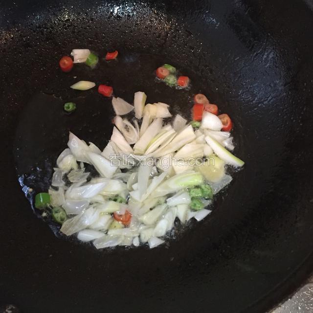 热锅下油放干辣椒 花椒爆香后捞起弃之再加入鲜辣椒 大蒜炒出香味