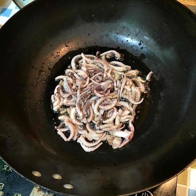 热锅下油，油温八成热倒入鱿鱼须煸炒