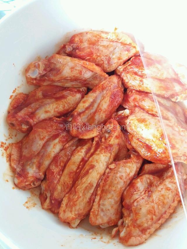 雞翼加入奧爾良醃料，拌均勻，鋪上保鮮紙放入冰箱醃過夜