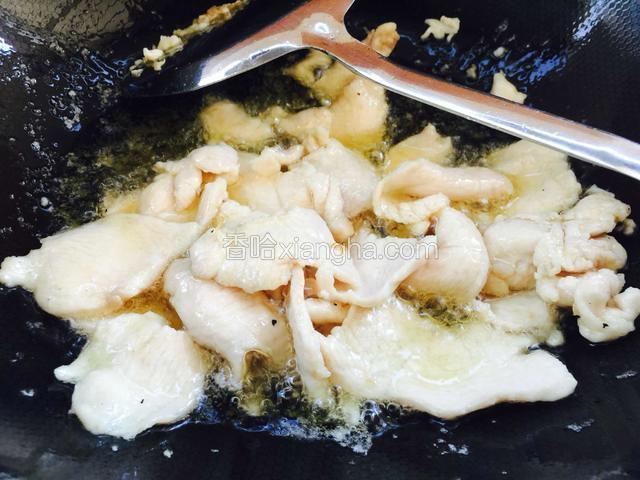 锅里倒入多一点的油，下入鸡片滑炒断生捞出，不要炒老了。