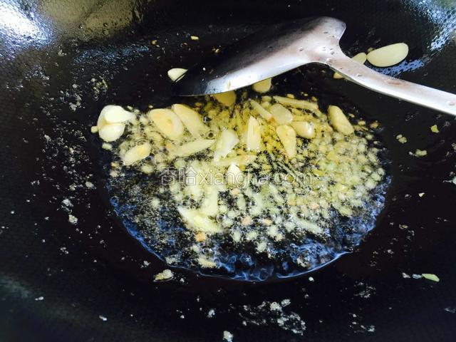 锅里就少许油，倒入姜末和蒜片煸炒出香味。
