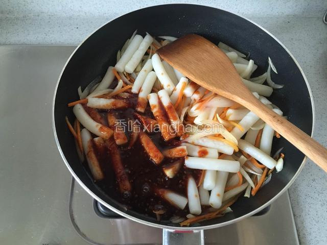 将煮熟的年糕条倒入平底锅内，加入辣酱。