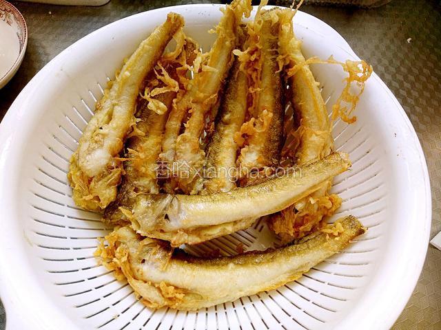 待炸至鱼身定型，颜色变黄时，捞出来沥油